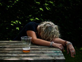 Midsection of woman sitting on table against blurred background