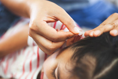 Nurse applying bandage over wound on girl ear