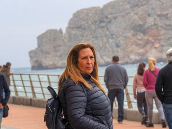 Portrait of woman standing against mountain