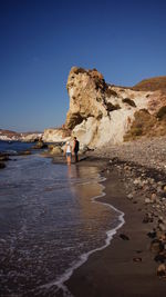 View of two people standing on beach shore