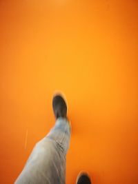 Low section of man on orange wall