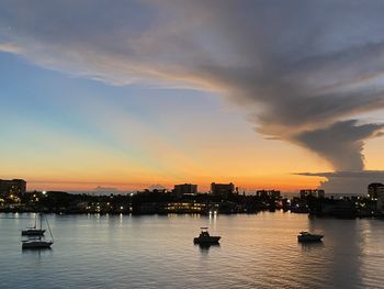 Silhouette buildings in city against sky during sunset