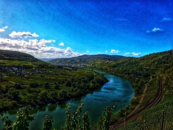 Scenic view of river and mountains against blue sky