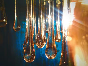 Close-up of illuminated light bulbs hanging from glass