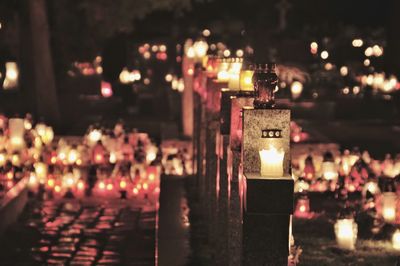 Illuminated candles on temple at night