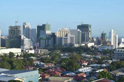 Aerial view of buildings in city against clear sky