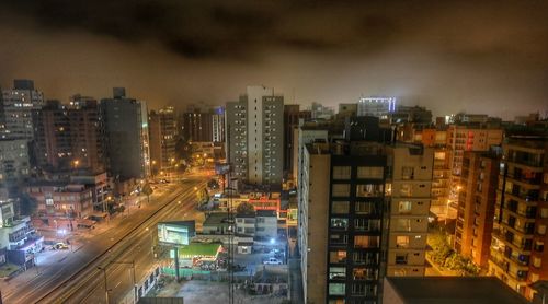 Illuminated cityscape against sky at night