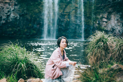 Portrait of woman crouching by plants