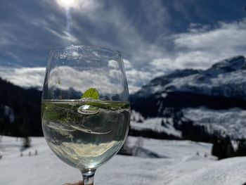 Glass of wineglass against sky and mountains