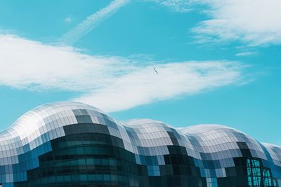 Low angle view of modern building against cloudy sky