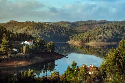 Scenic view of lake by trees against sky