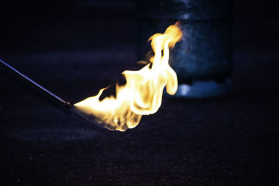 Close-up of yellow fire burning in the dark