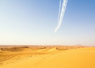 Scenic view of desert against blue sky