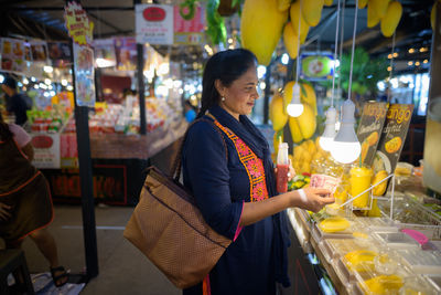 Woman standing in market at night