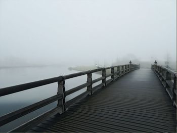 Pier over sea against sky during winter