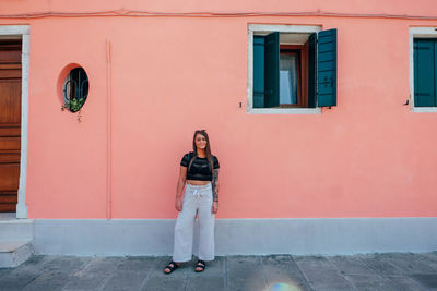 Portrait f woman standing against building