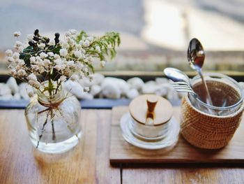 Close-up of flowers in vase by desk organizer on table