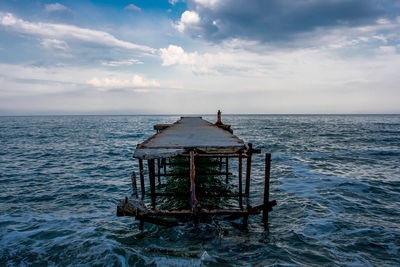 Lifeguard hut on sea against sky