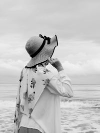 Rear view of woman looking at sea shore against sky