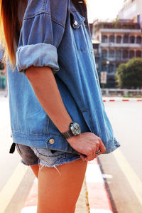 Side view of fashionable young woman standing on road in city