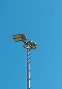 Low angle view of floodlight against clear blue sky