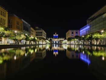 Reflection of buildings in lake at night