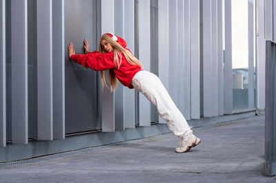 Cheerful african american woman with long blonde hair wearing sportswear and wearing headphones