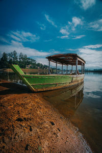 Abandoned boat on beach against sky