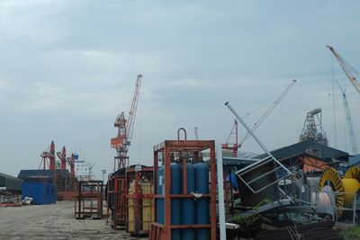 Cranes at construction site against sky