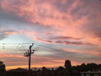 Silhouette electricity pylon against sky during sunset