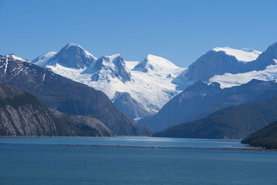 Scenic view of snowcapped mountains against blue sky