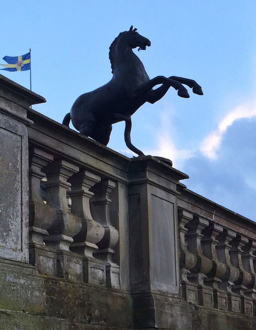 sculpture, statue, human representation, low angle view, art and craft, art, architecture, built structure, creativity, building exterior, sky, animal representation, outdoors, day, famous place, cloud - sky, blue, cloud