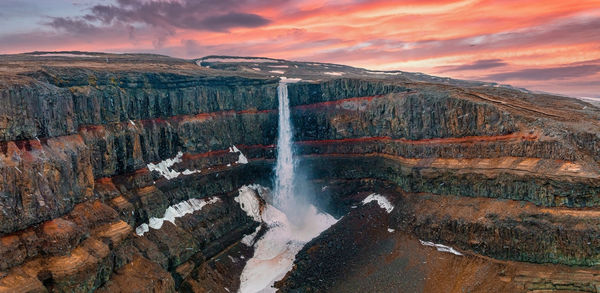 Aerial view on hengifoss waterfall with red stripes sediments in iceland.