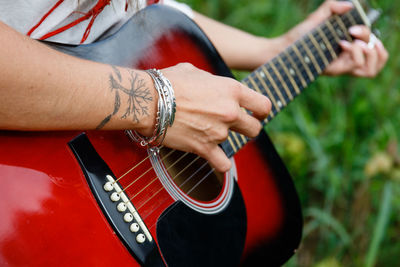 Midsection of woman playing guitar