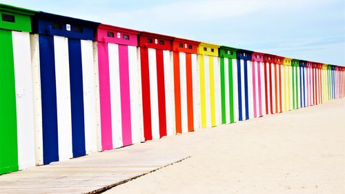 Multi colored umbrellas on beach against sky