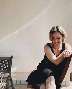 Portrait of smiling young woman sitting on seat