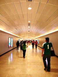 People walking in illuminated corridor