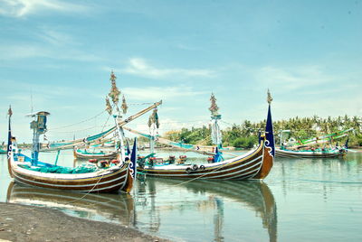 Boats moored in sea against sky