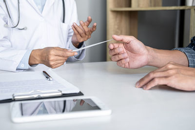 Midsection of doctor examining patient in office