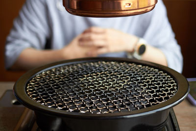 Close-up of man holding tea cup on table