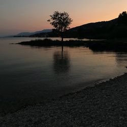 Scenic view of lake against sky at sunset