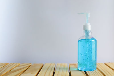 Close-up of blue bottle on table against wall