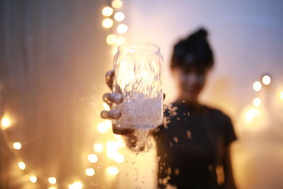 Rear view of a woman drinking glass at sunset