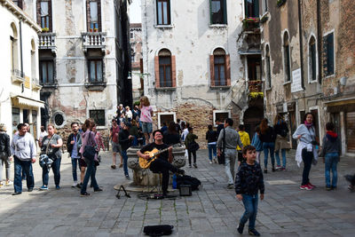 People walking on street amidst buildings in city