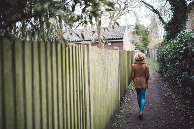 Rear view of woman walking on footpath