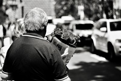 Rear view of man with umbrella on street