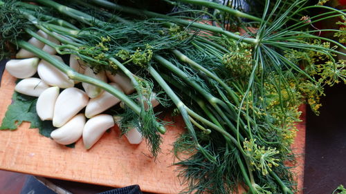 Close-up of garlic and dill on cutting board