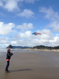 Low angle view of helicopter flying over beach against sky