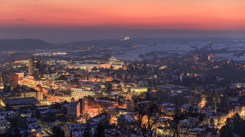 High angle view of illuminated cityscape against sky at dusk