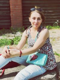 Portrait of a smiling young woman sitting outdoors